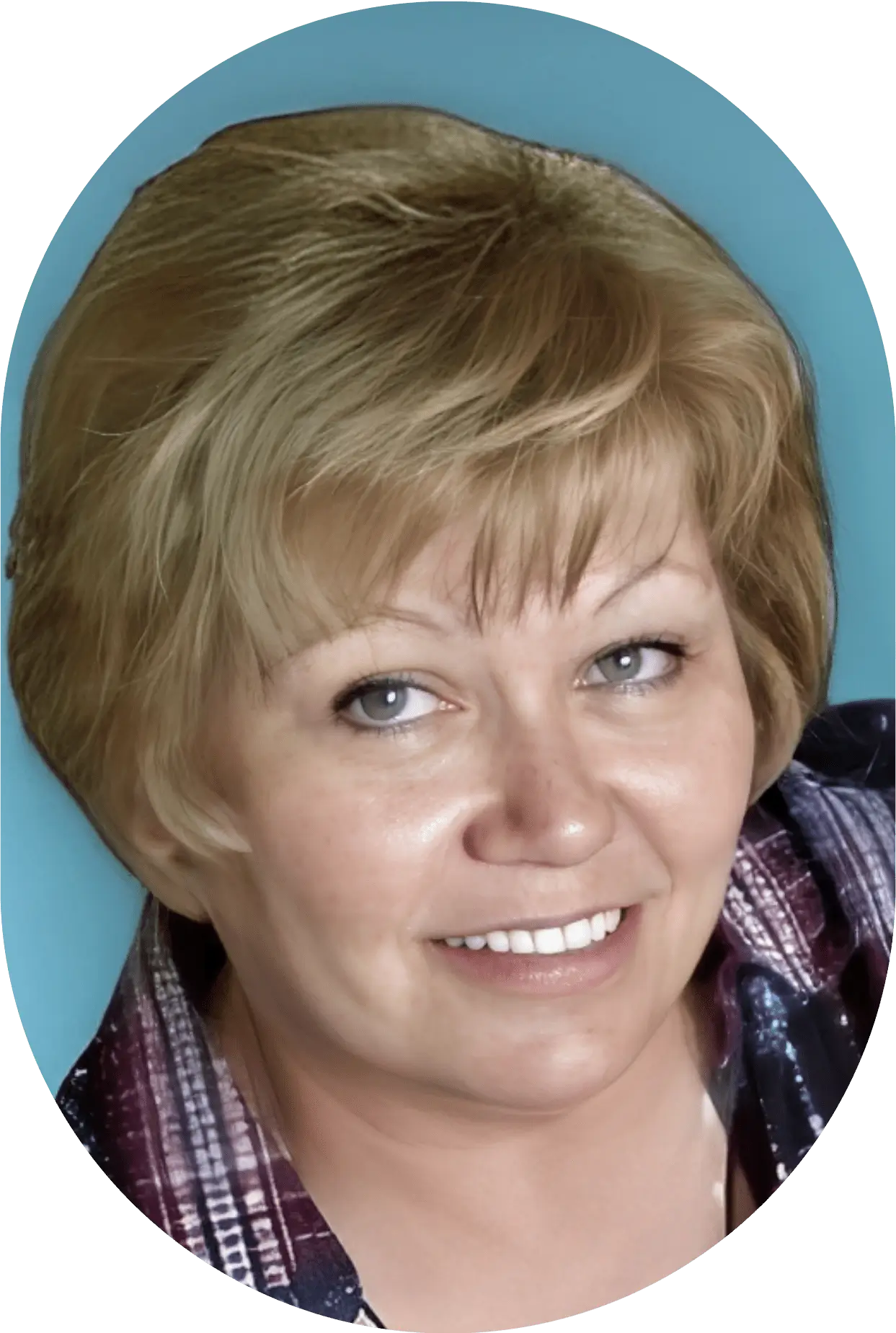 Smiling woman with short blonde hair and light blue eyes.