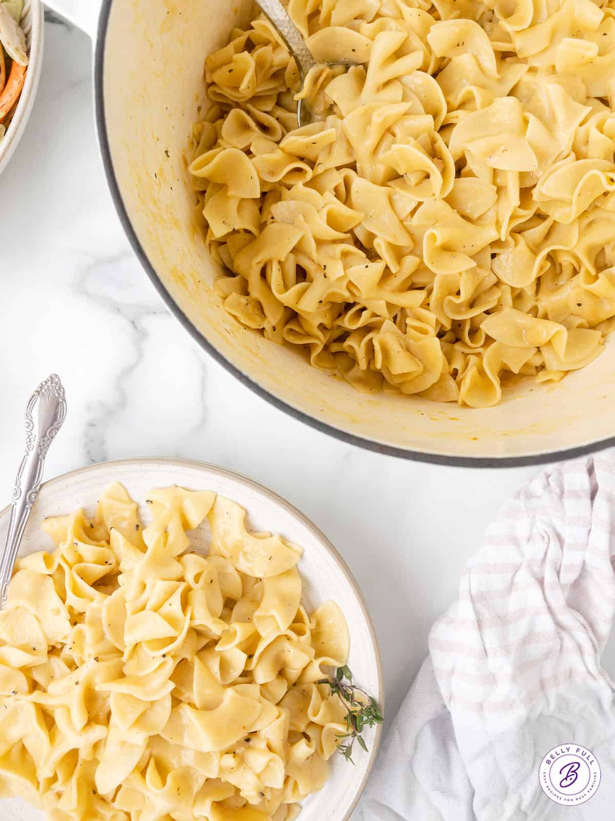 Bowl and plate of cooked egg noodles.